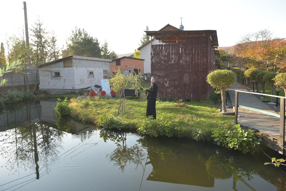 A pond, footbridge and buildings in the community grounds