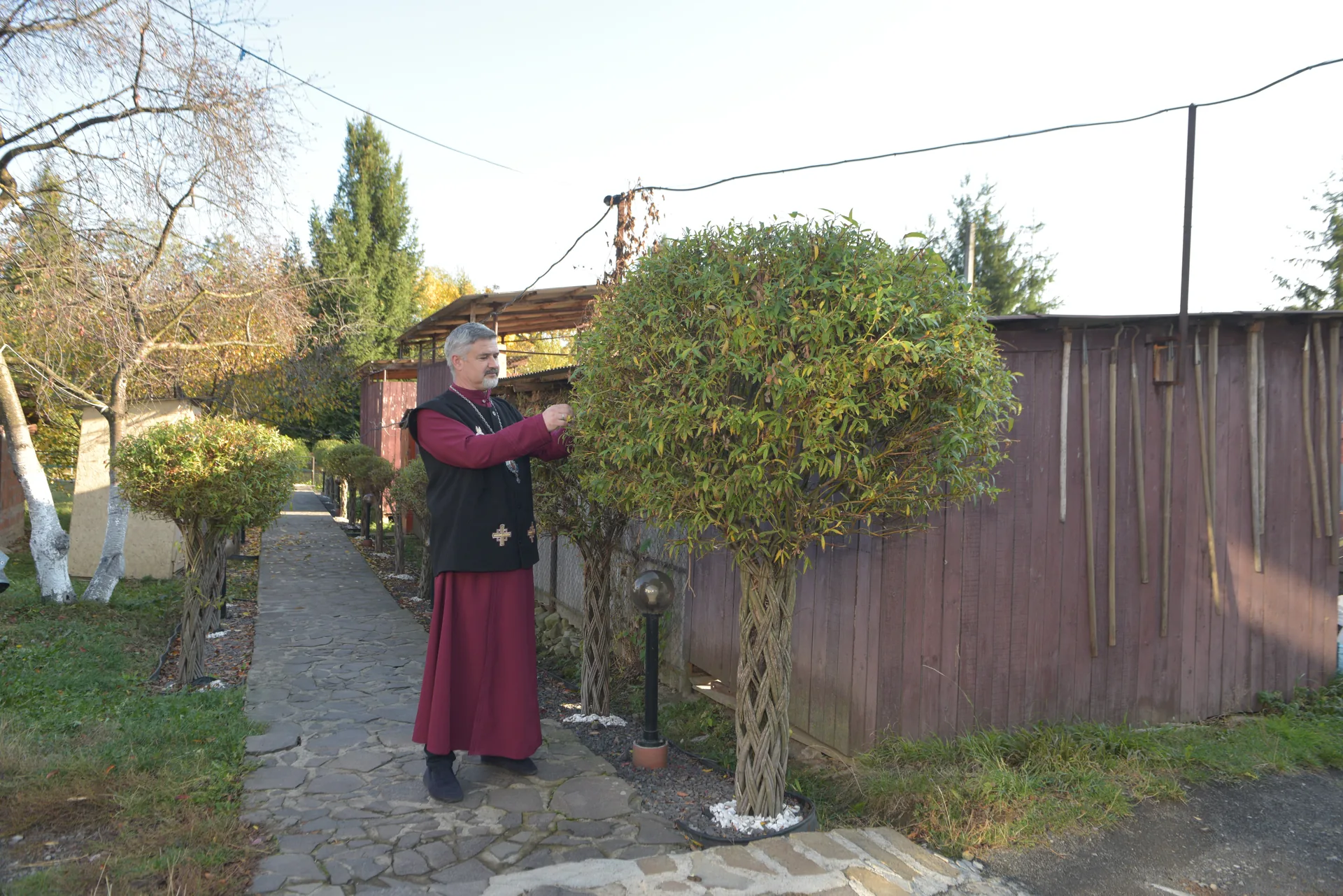 An ornamental plant and a clergy member on a garden path
