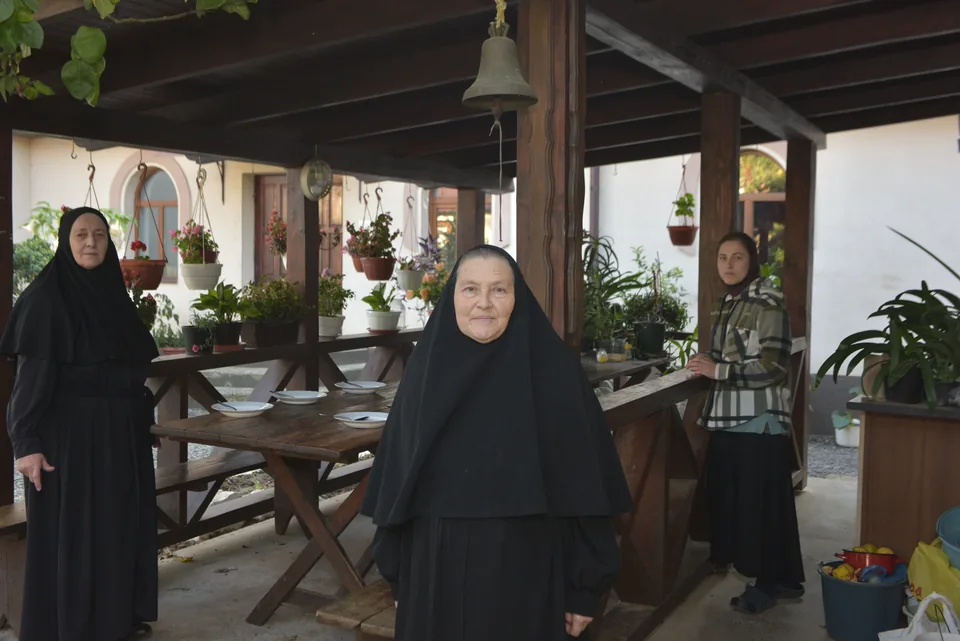 Community sisters beside a table in an open-sided pavilion