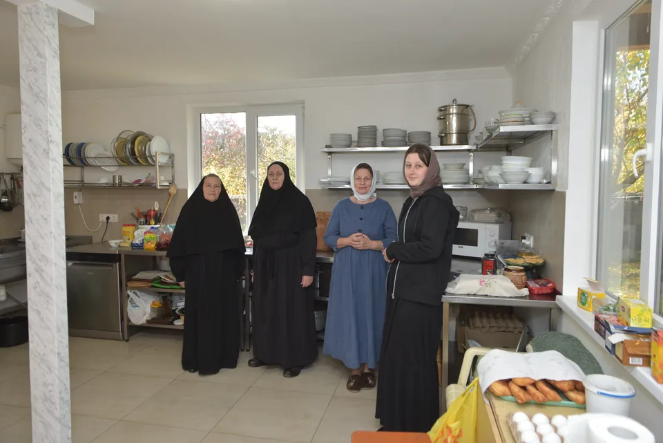 Sisters beside the social kitchen equipment.