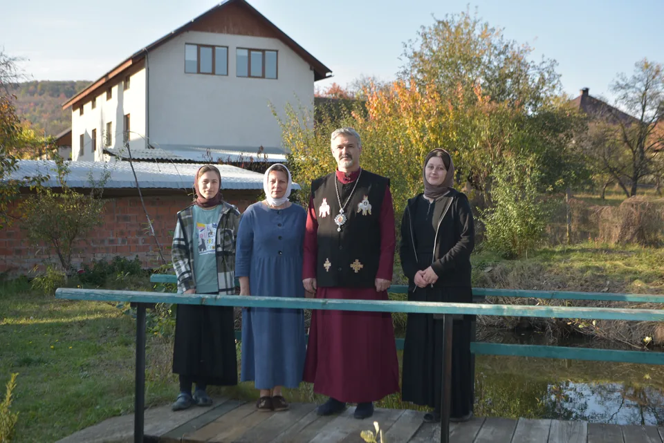 A group photograph on a footbridge beside a pond