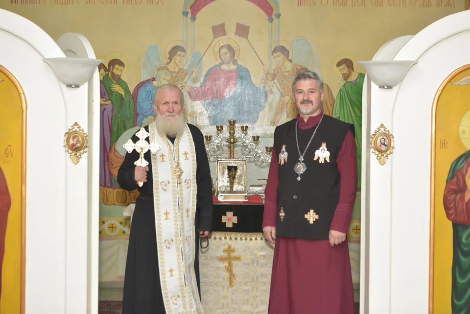 Two clergy standing in front of the iconostasis